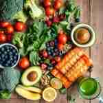 Dieta antinfiammatoria come ridurre l'infiammazione Dieta antinfiammatoria: Alimenti della dieta antinfiammatoria: salmone, verdure, frutti di bosco e noci su tavola rustica